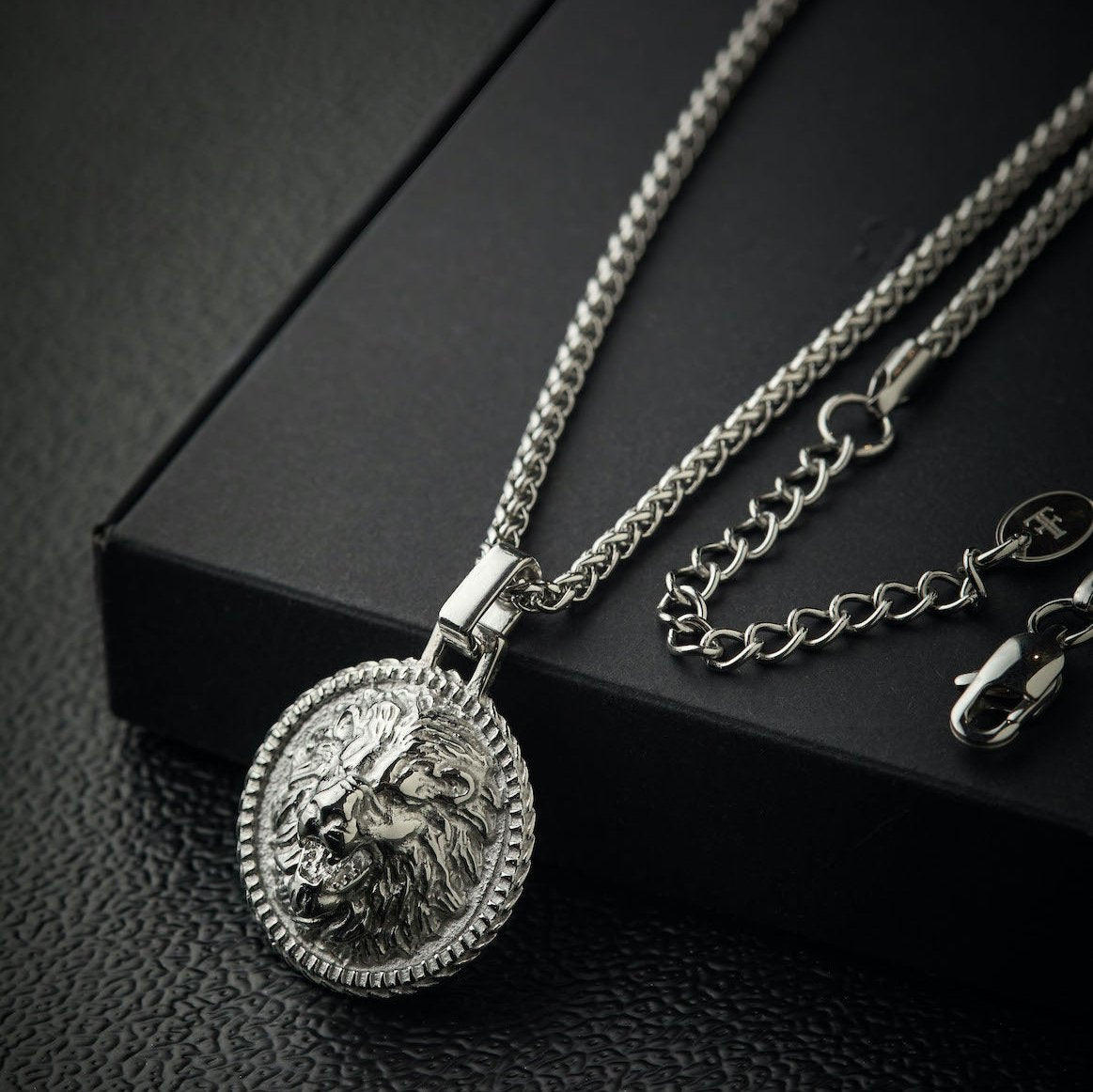 Men's polished stainless steel lion pendant on packaging