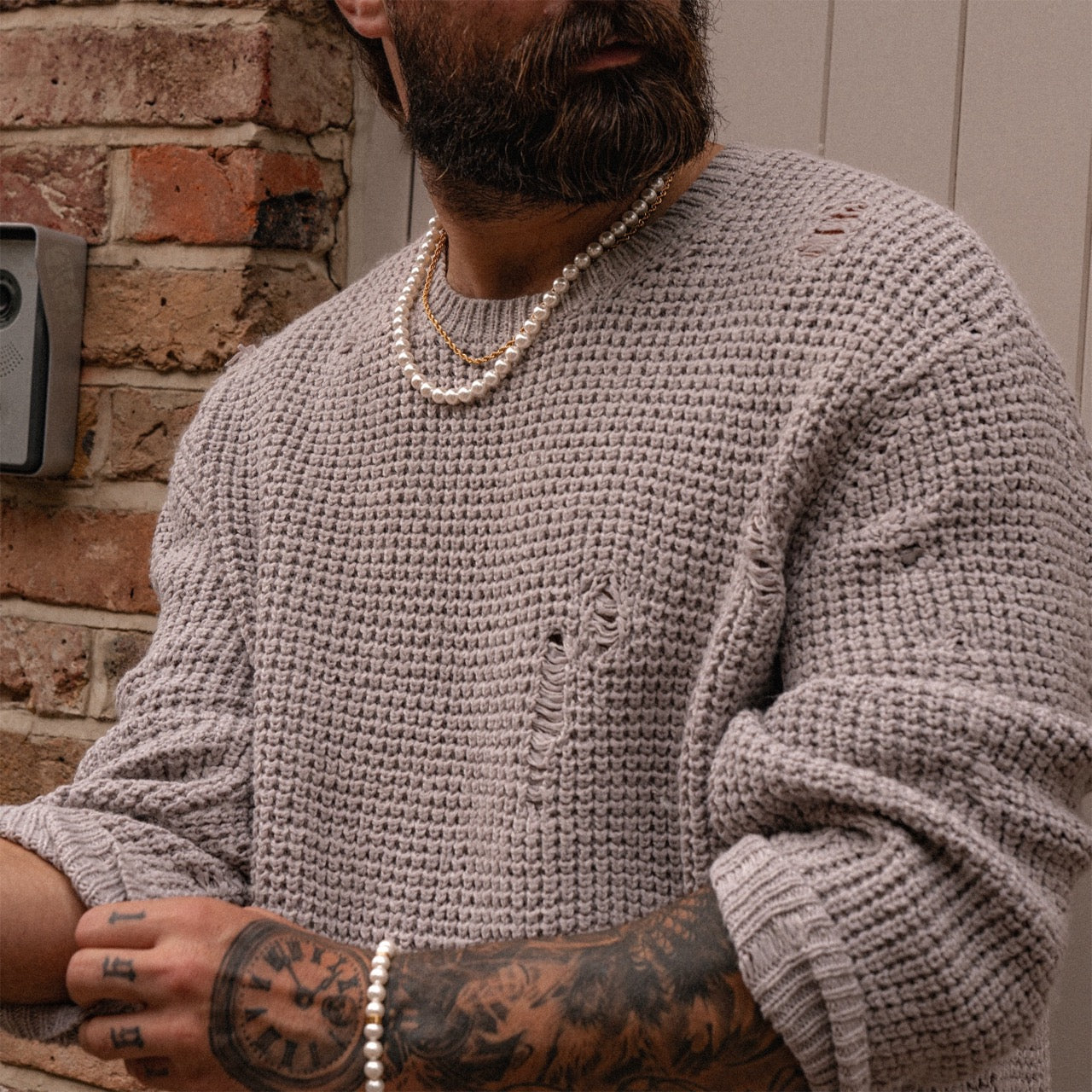 Men's pearl necklace with gold metal accents on model