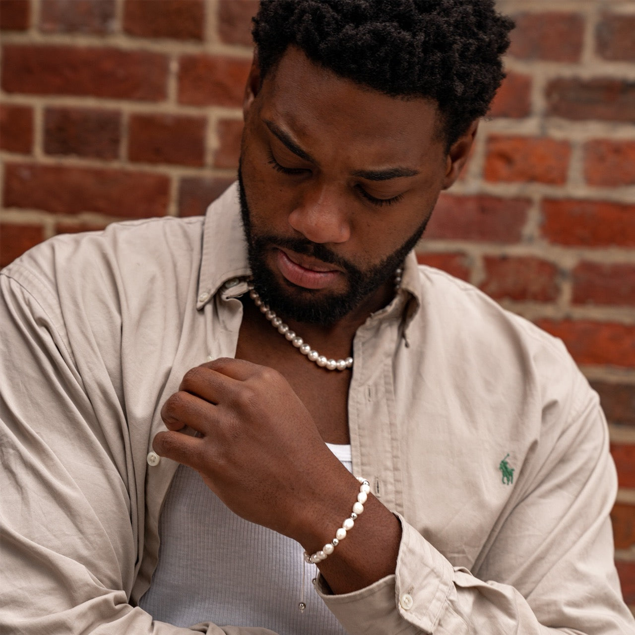 Men's pearl necklace with silver metal accents on model