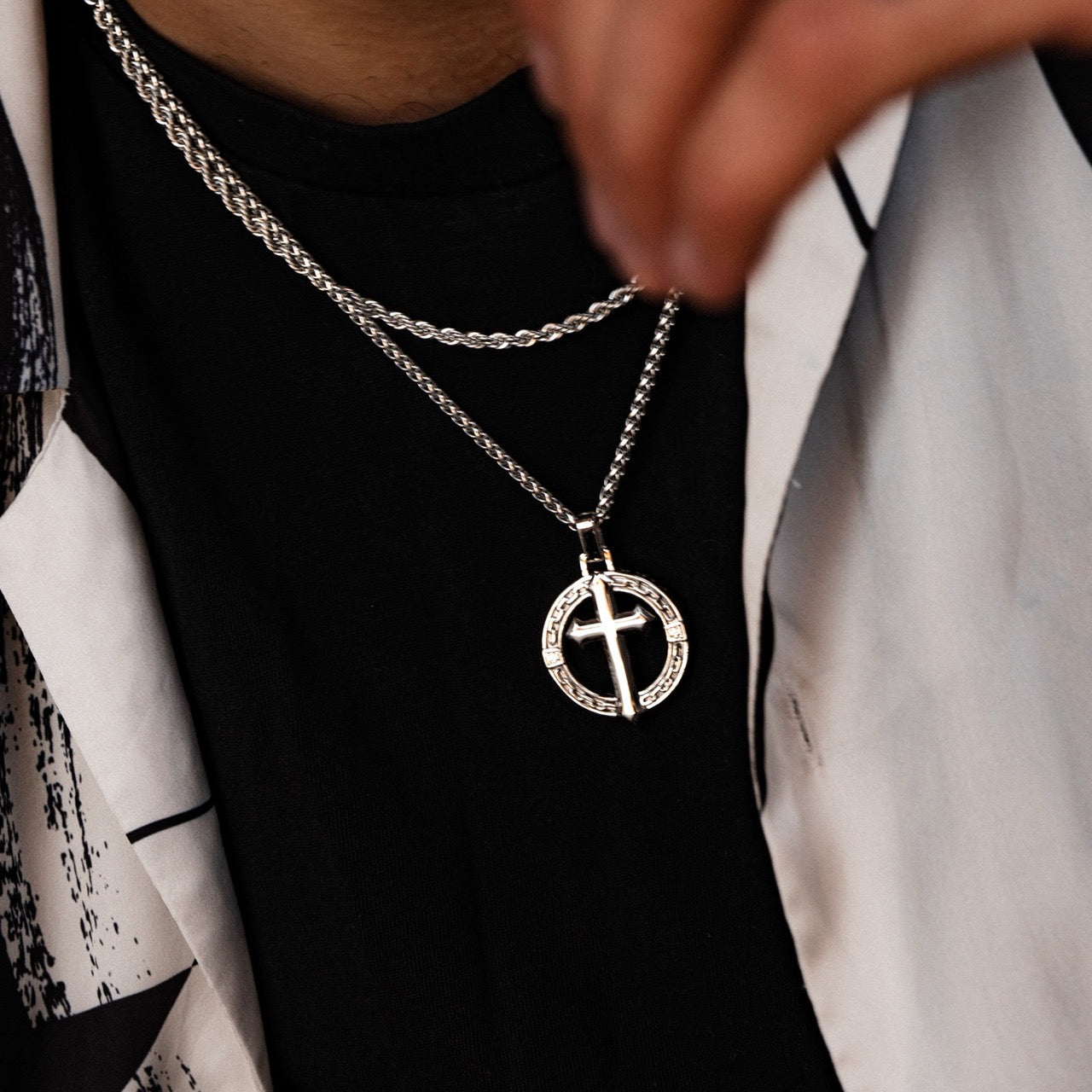 Men's silver cross pendant necklace on model
