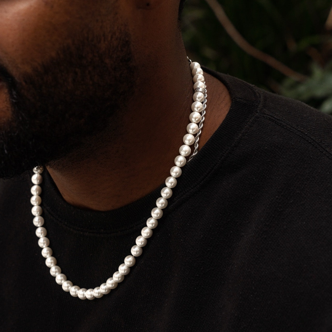 Men's pearl necklace with silver metal accents on model