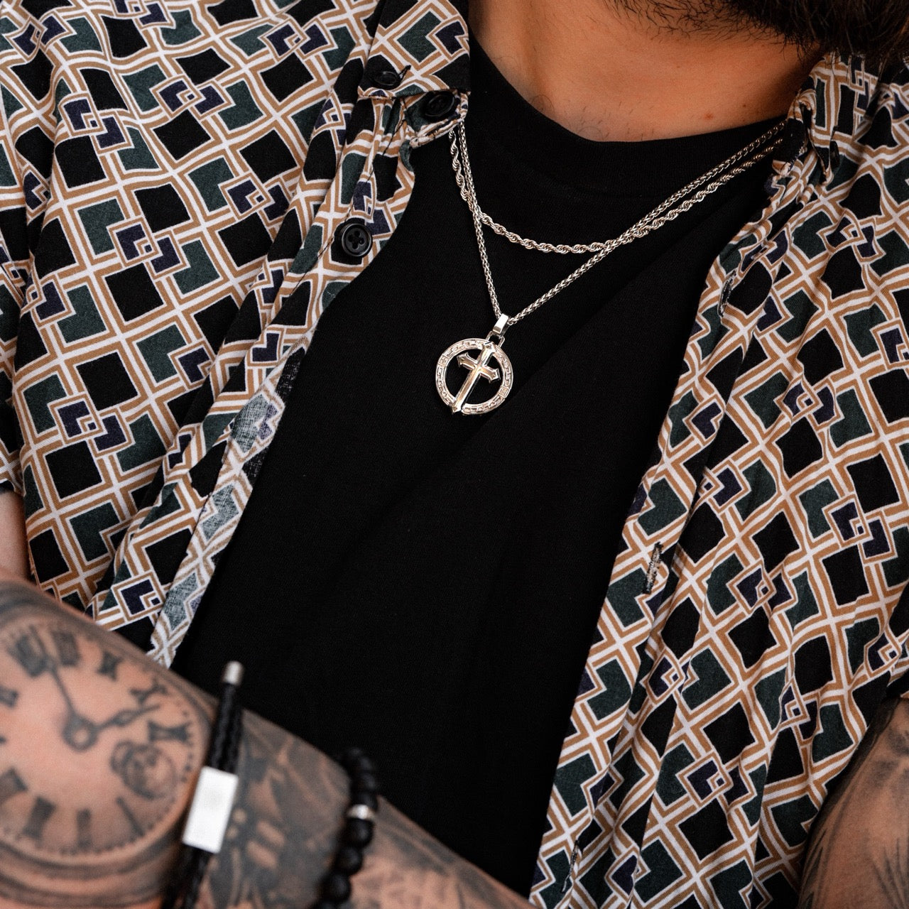 Men's silver cross pendant necklace on model