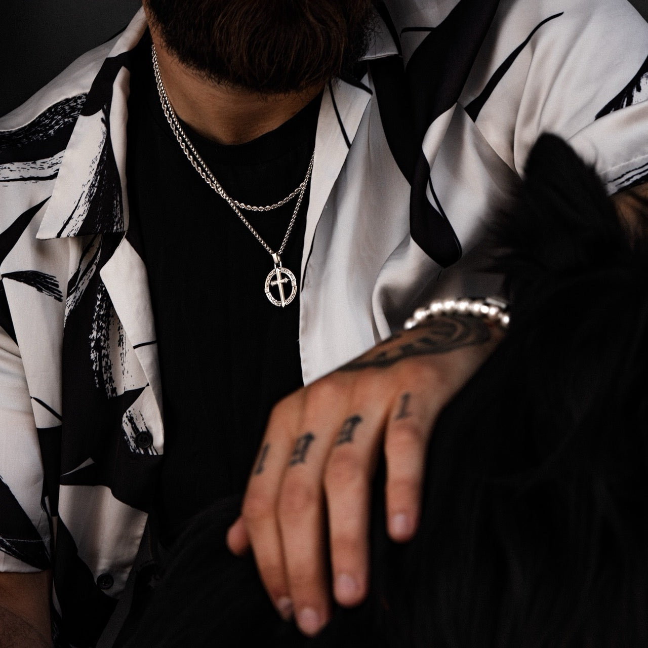 Men's silver cross pendant necklace on model