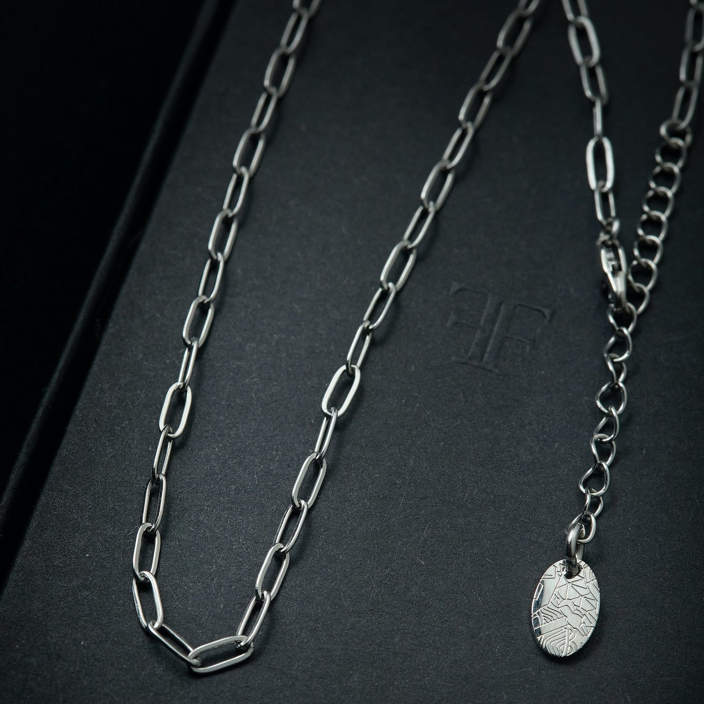 Men's silver paperclip layering necklace chain on packaging box