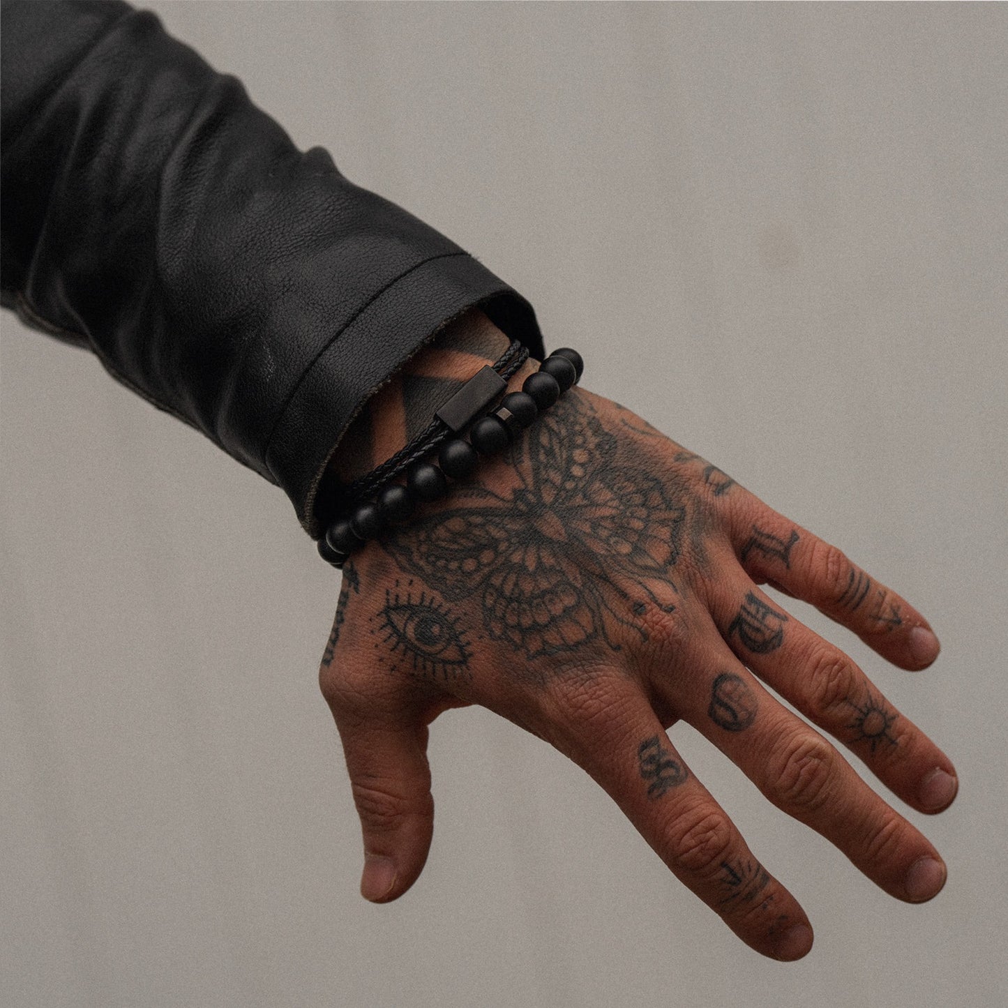Men's 10mm onyx matte bead bracelet on model with leather bracelet