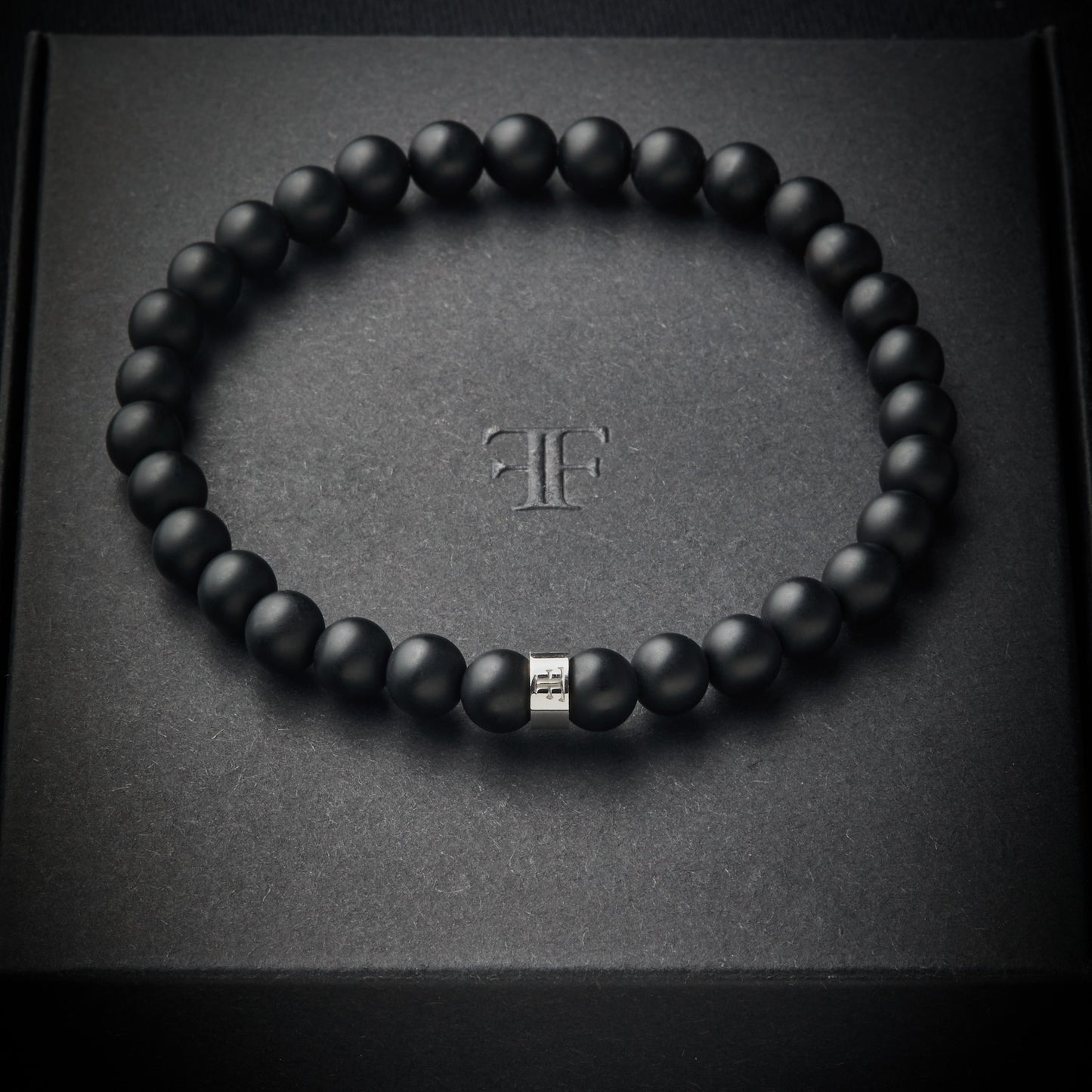 Mens black and silver onyx beaded stone bracelet on packaging