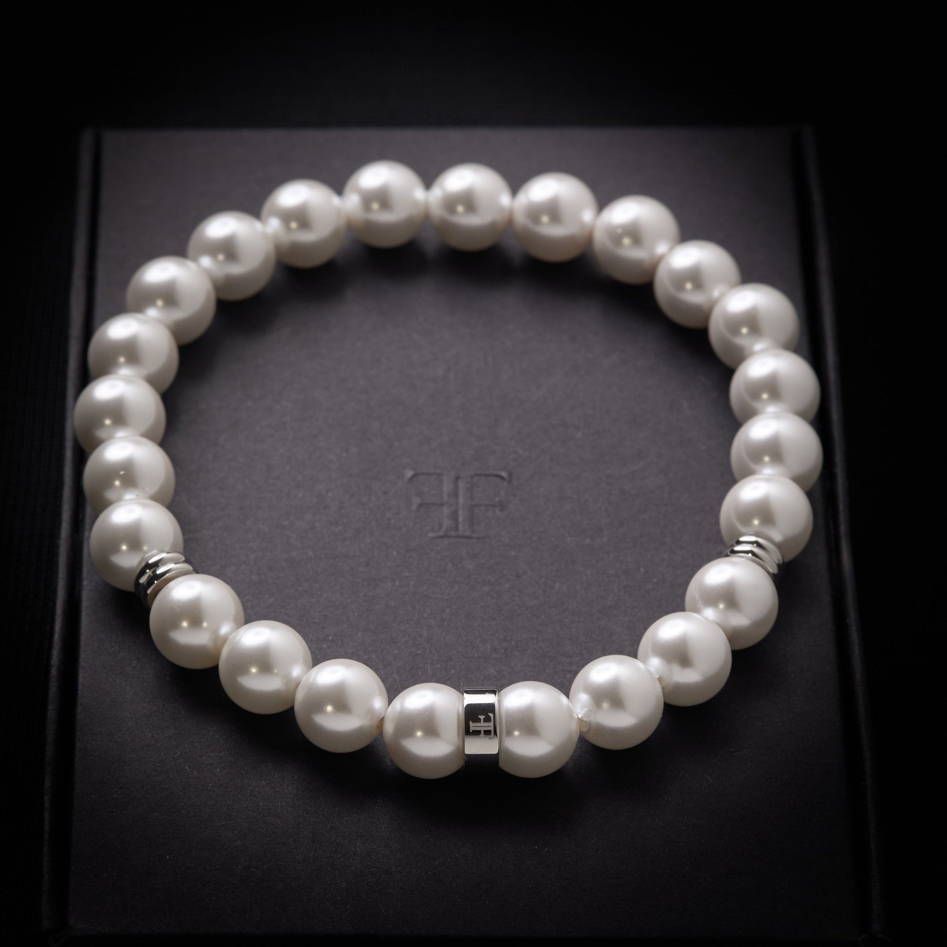 Mens' 8mm shell pearl bracelet with silver accent beads on packaging box
