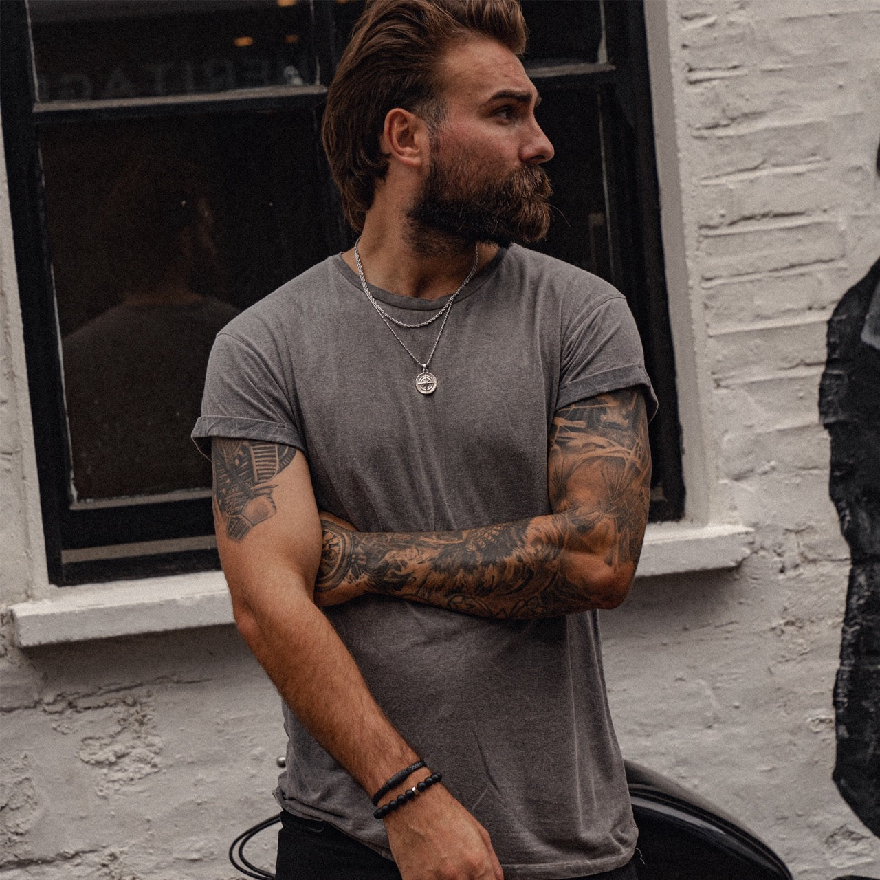 Men's silver compass pendant necklace on model