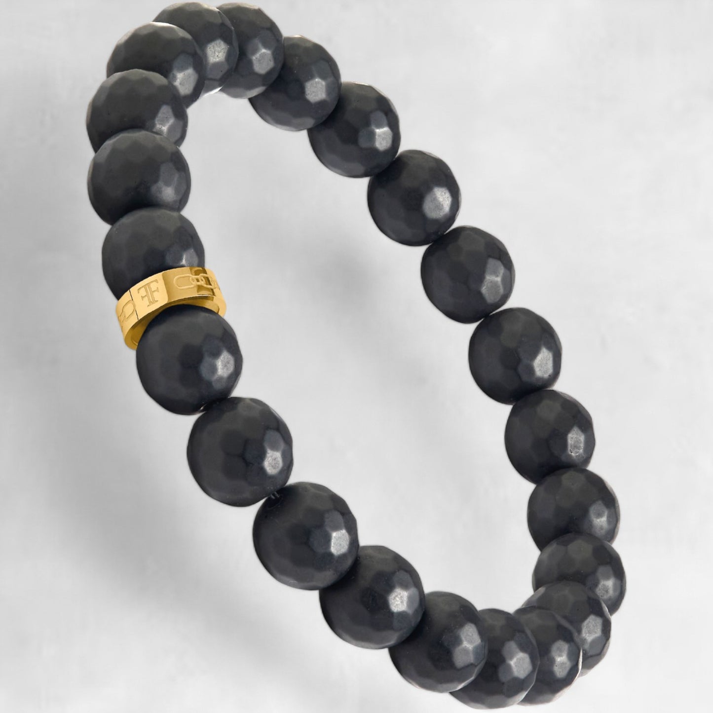 Men's black faceted onyx bead bracelet with gold accent bead