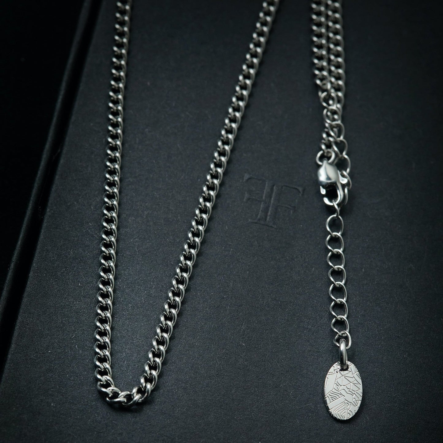 Men's silver cuban layering chain necklace on packaging box
