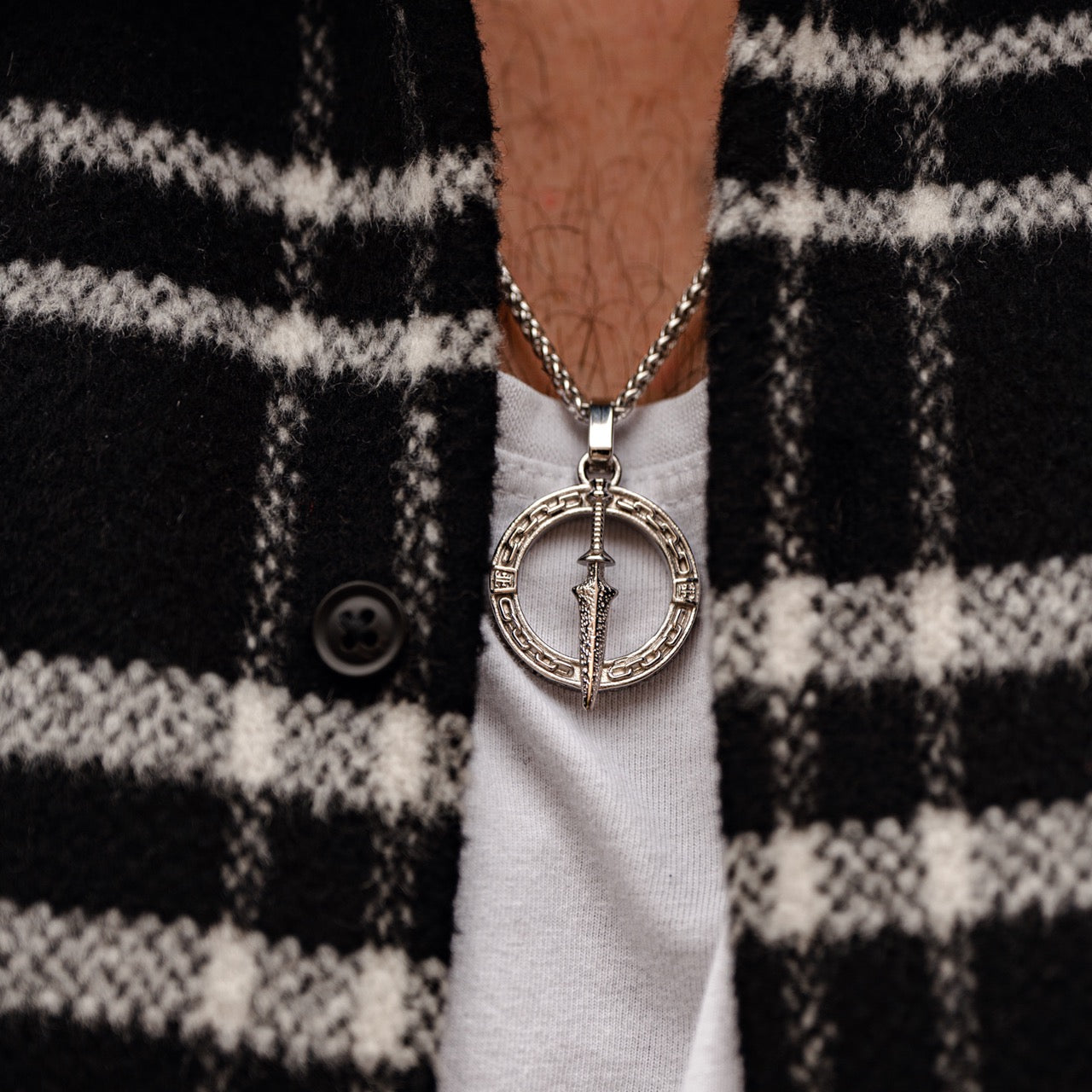 Men's silver dagger pendant necklace on model