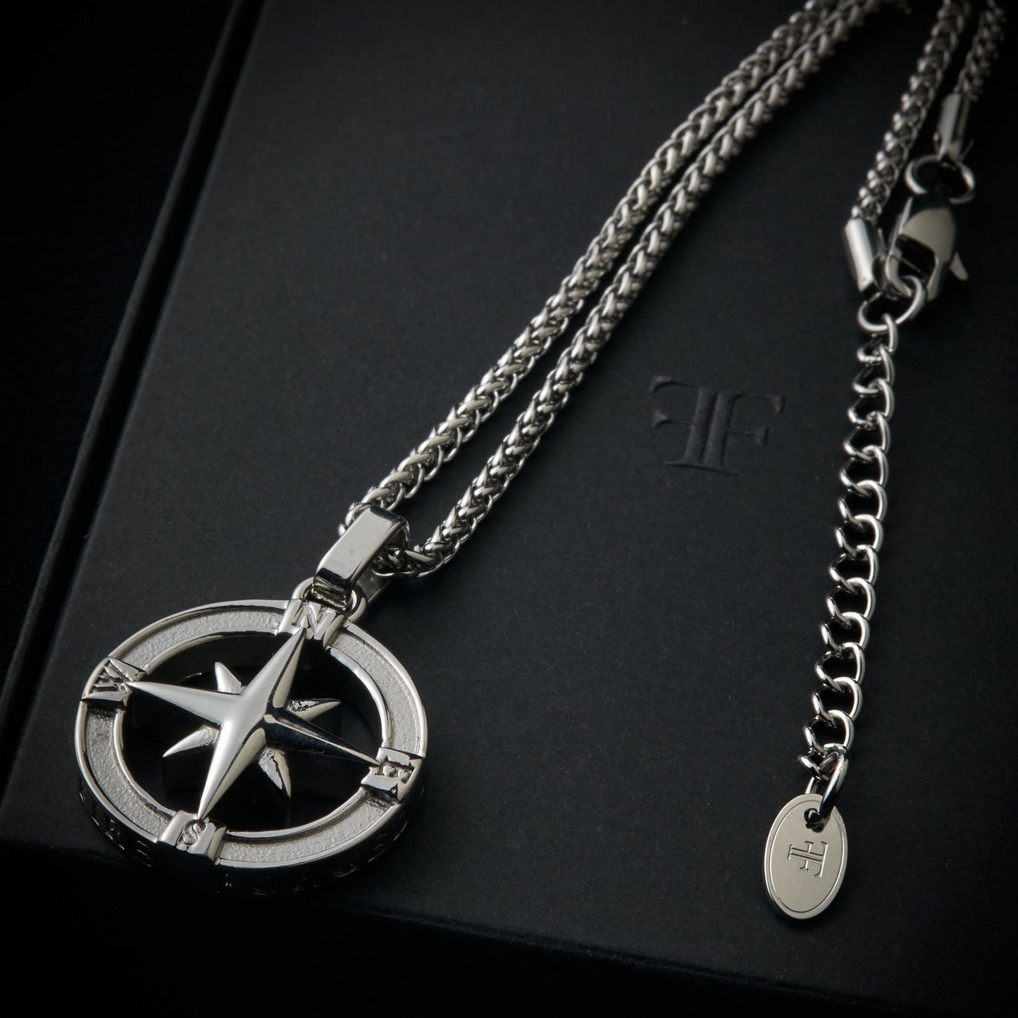 Men's silver North Star pendant necklace on packaging box