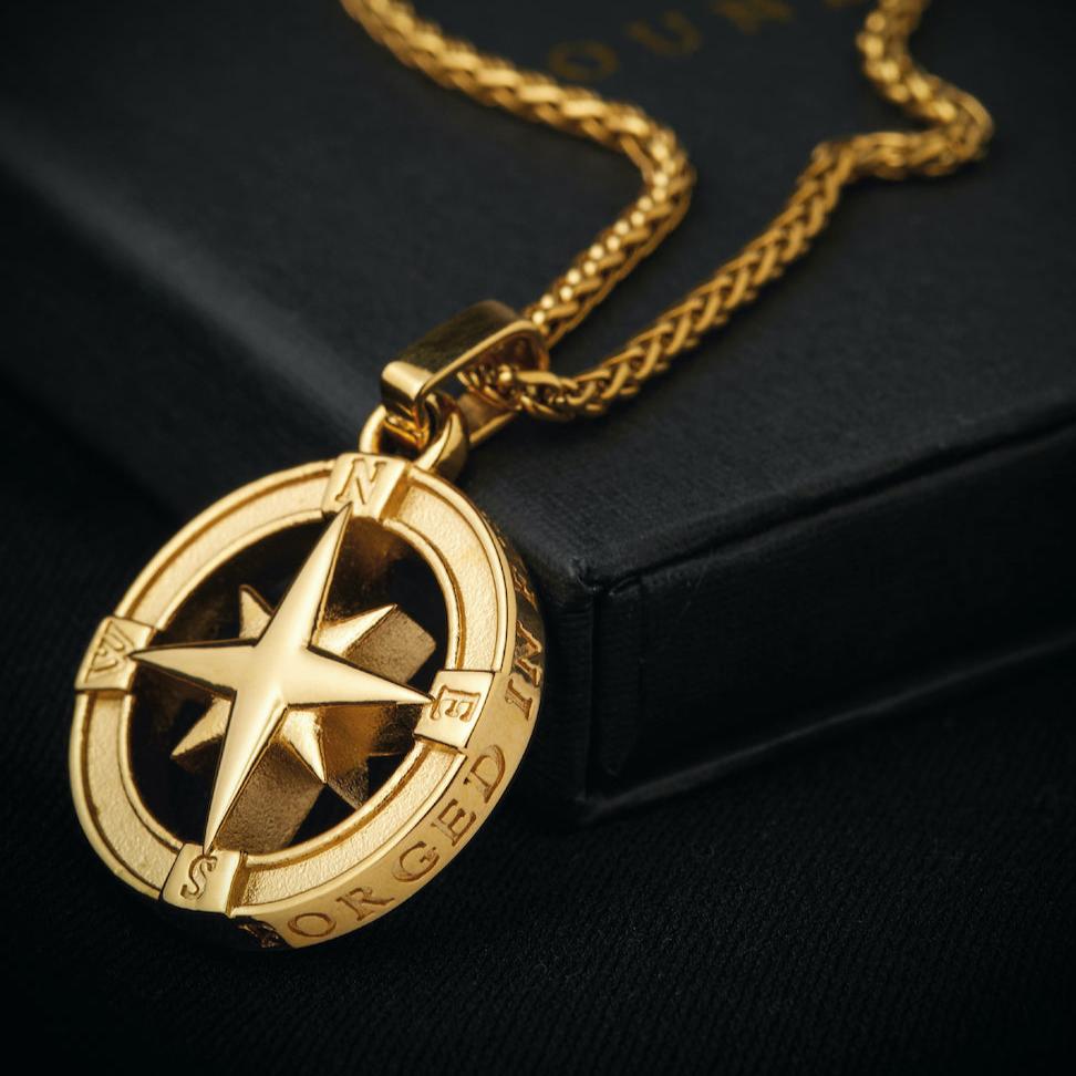 Men's gold North Star pendant necklace on packaging box
