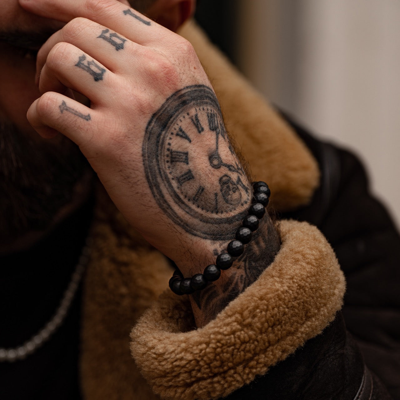 Men's faceted black bead bracelet with black accent on model