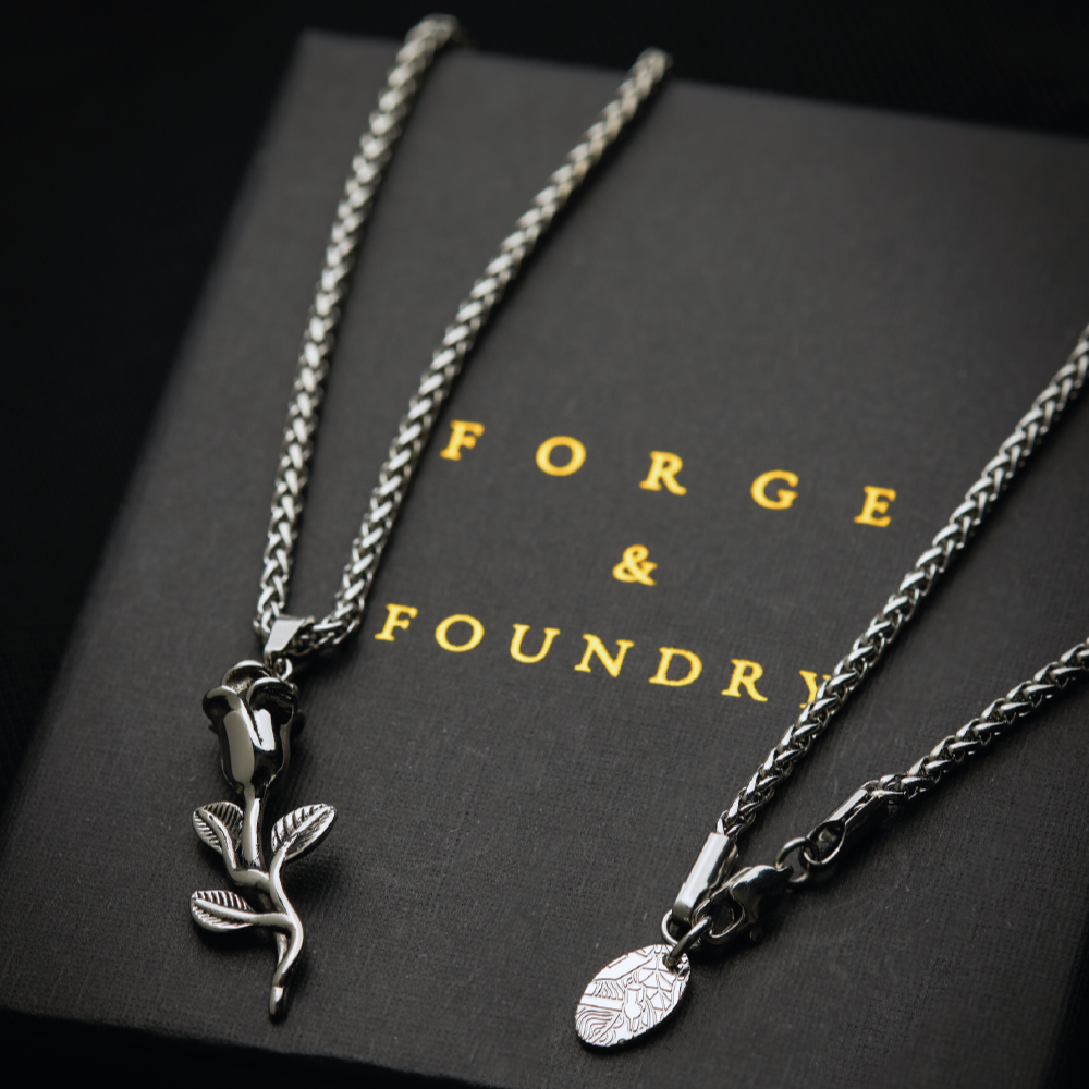 Men's silver rose pendant necklace on packaging box