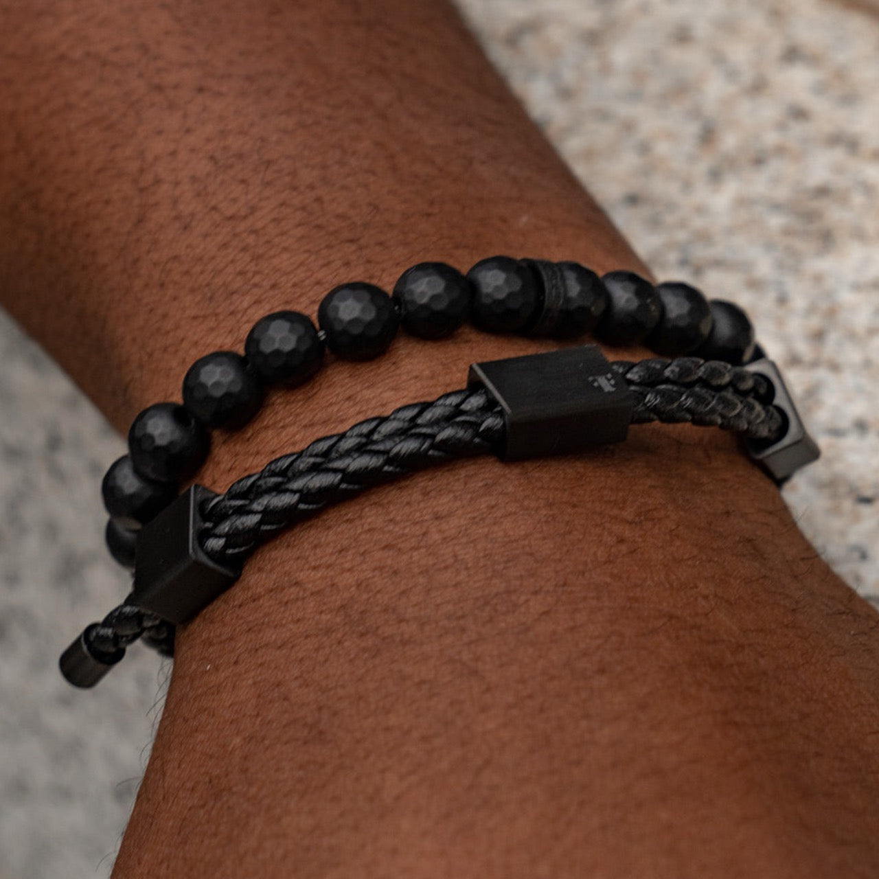 Men's black faceted onyx bead bracelet with black accent bead on model