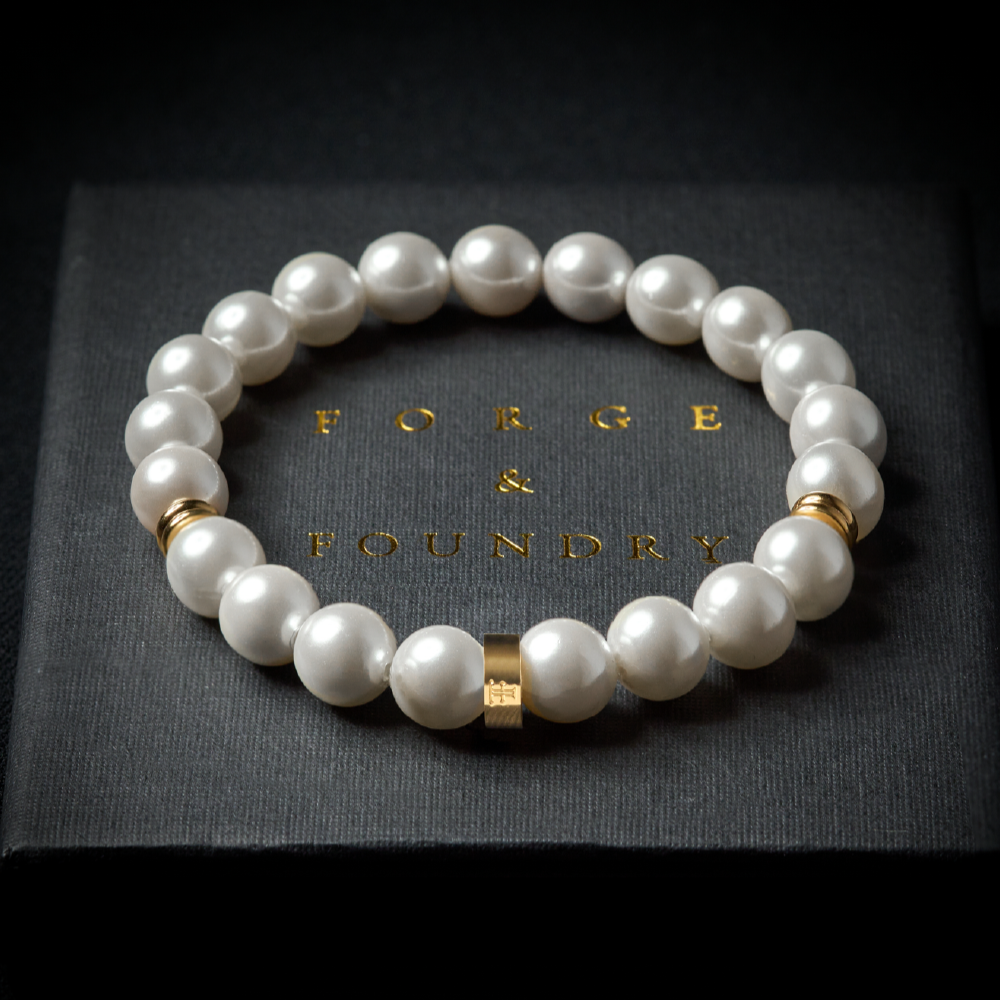 Men's 8mm shell pearl bracelet with gold accent beads on packaging box