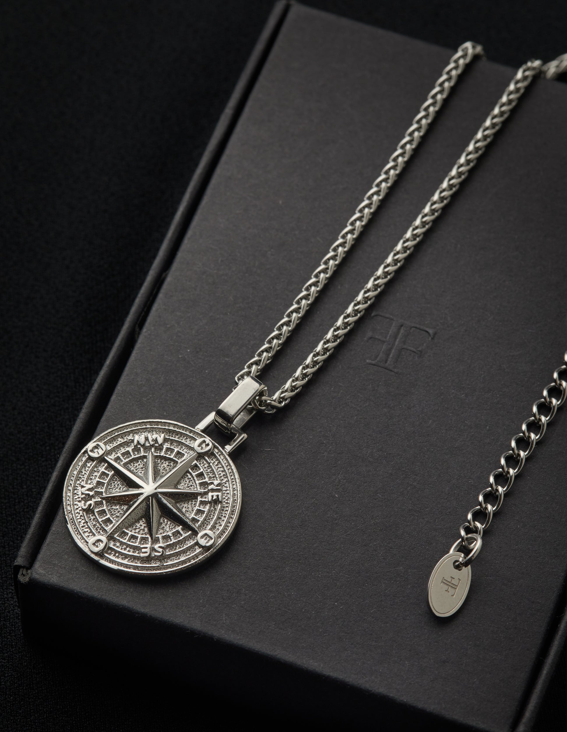 Mens stainless steel compass pendant on packaging