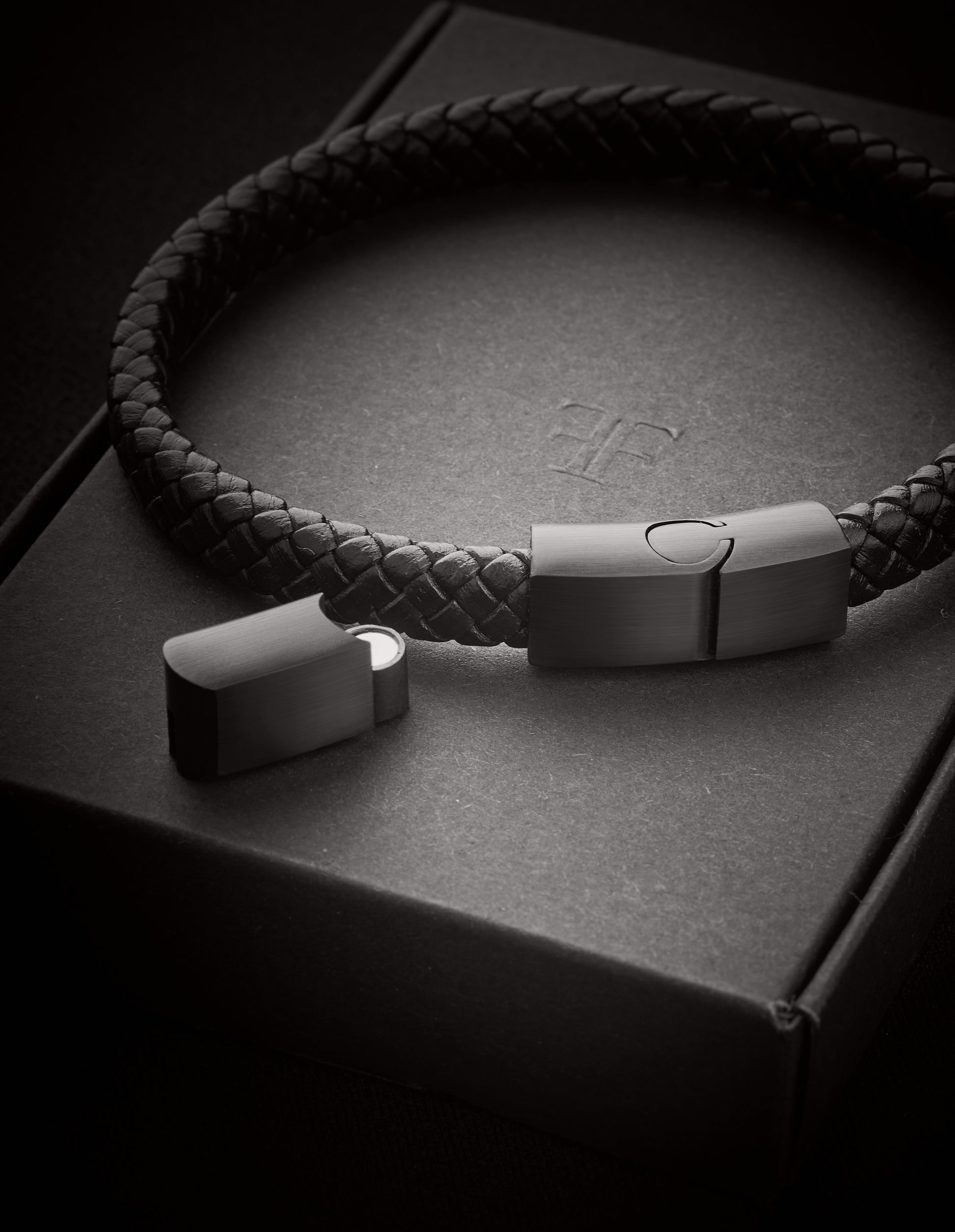 Men's black braided adjustable leather bracelet on packaging