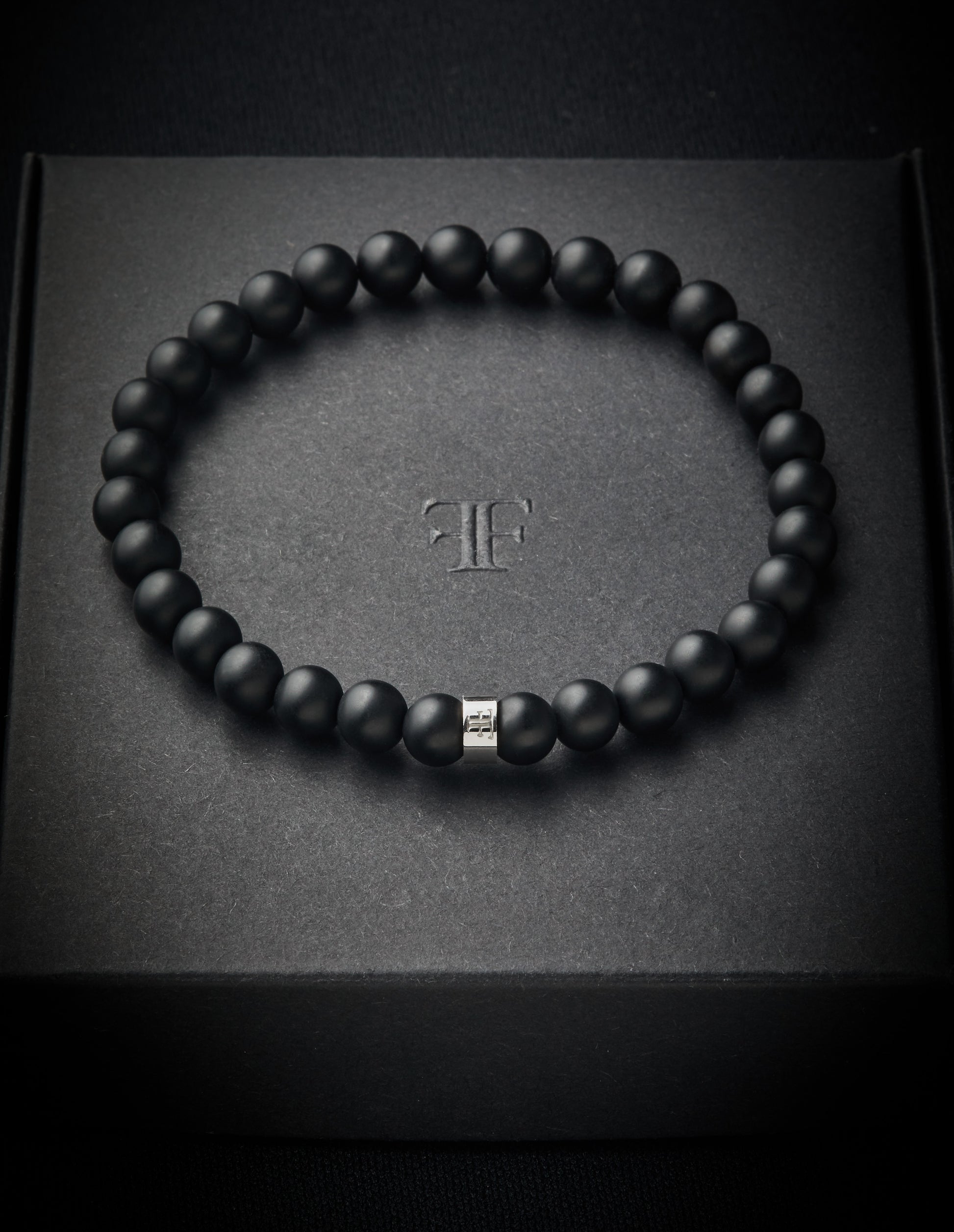 Mens black and silver onyx beaded stone bracelet on packaging