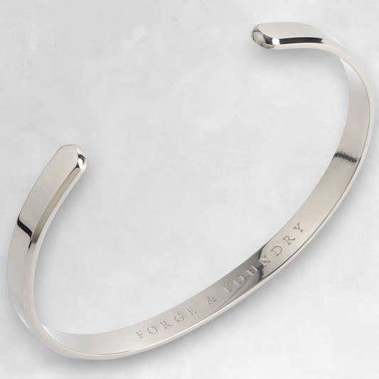 Polished, titanium Ravick cuff bracelet with a minimalist design, featuring a slimline band and bevelled edges.