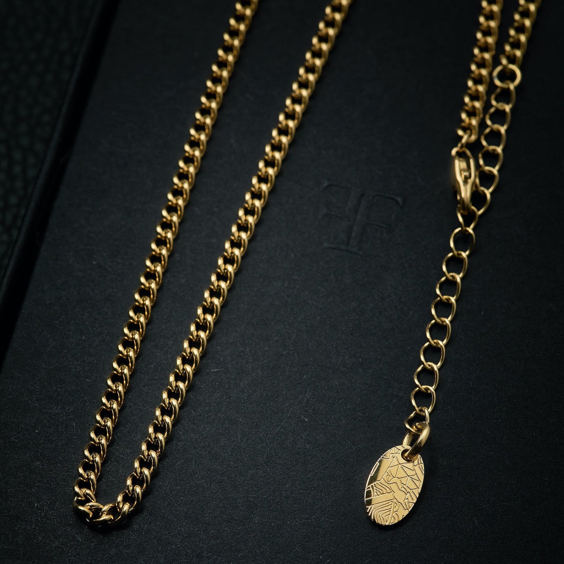 Men's gold cuban layering chain necklace on packaging box