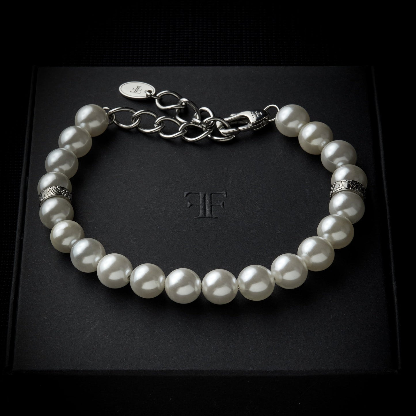 Men's adjustable shell pearl bracelet with silver accent beads on packaging box